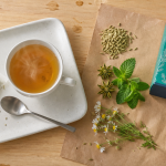 Tisane pour ventre plat, graines de fenouil et menthe sur table en bois